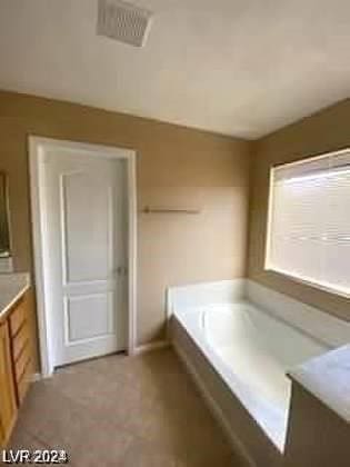 bathroom featuring a washtub and vanity