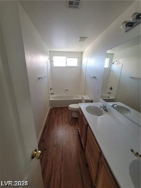 full bathroom featuring hardwood / wood-style floors, vanity, toilet, and  shower combination