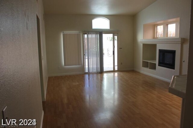 unfurnished living room featuring built in features and wood-type flooring