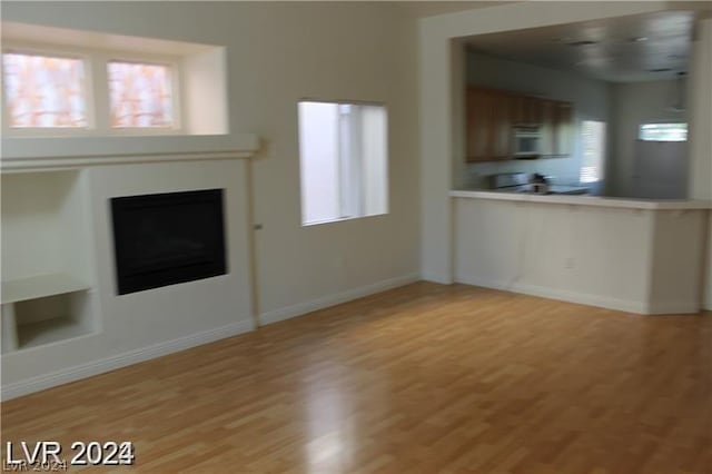 unfurnished living room featuring a wealth of natural light and light wood-type flooring