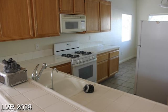 kitchen featuring tile countertops and white appliances