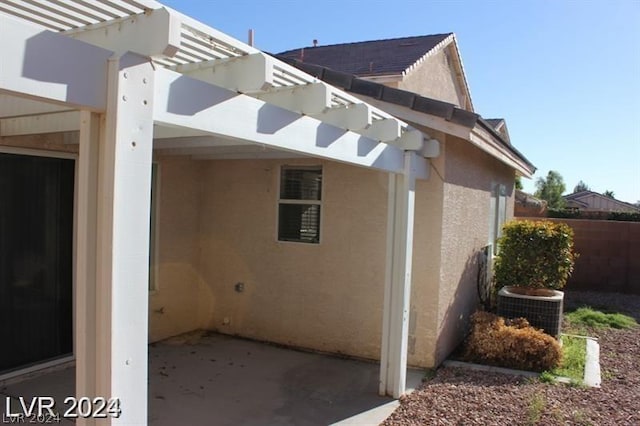 view of side of property with a patio and central air condition unit