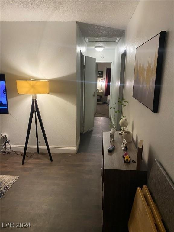 hallway with baseboards and a textured ceiling