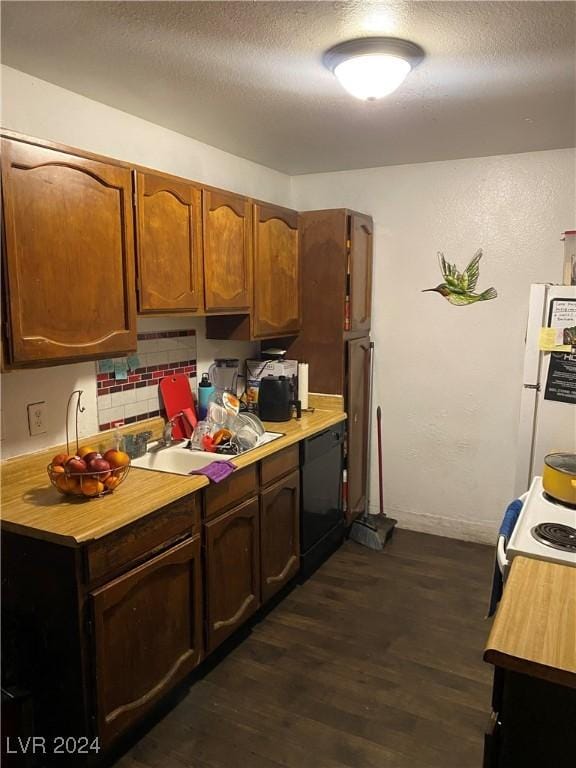 kitchen with white appliances, a textured ceiling, light countertops, decorative backsplash, and dark wood-style floors