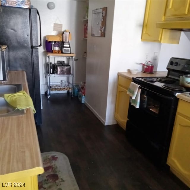 kitchen featuring dark wood finished floors, electric panel, under cabinet range hood, light countertops, and black / electric stove