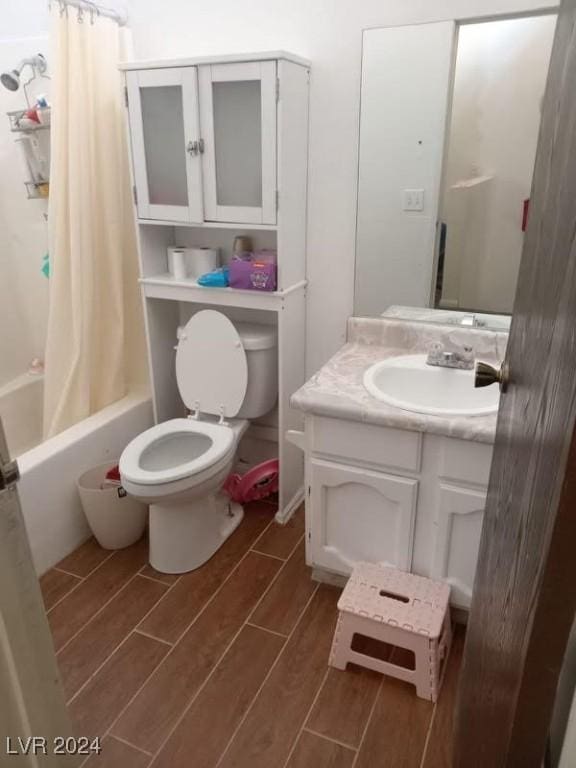 full bathroom featuring shower / bath combo, toilet, wood finish floors, and vanity
