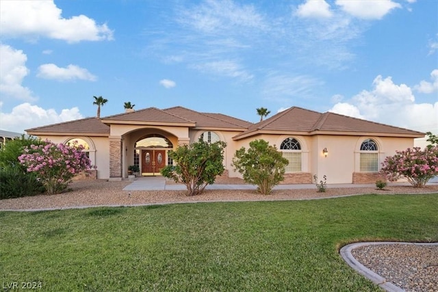 mediterranean / spanish-style house featuring a front lawn