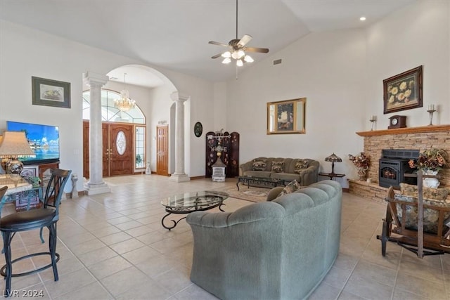 tiled living room with ornate columns, ceiling fan, and high vaulted ceiling