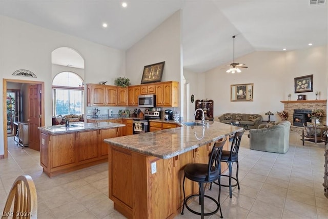 kitchen featuring appliances with stainless steel finishes, sink, a breakfast bar, and kitchen peninsula