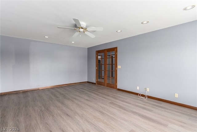 empty room with ceiling fan, french doors, and light wood-type flooring