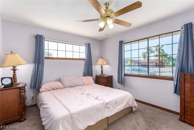 bedroom featuring ceiling fan, carpet floors, and multiple windows