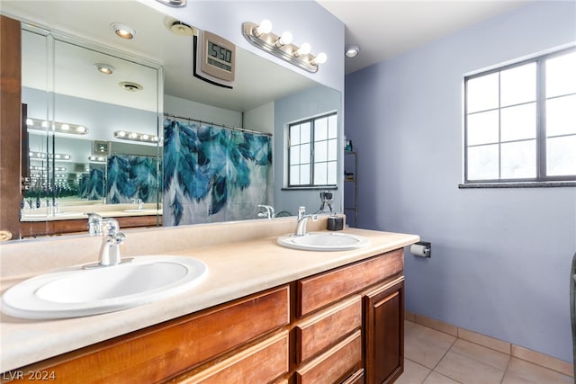 bathroom with tile floors, a wealth of natural light, and dual vanity