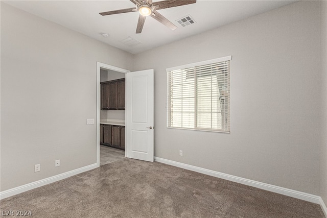 carpeted spare room featuring ceiling fan