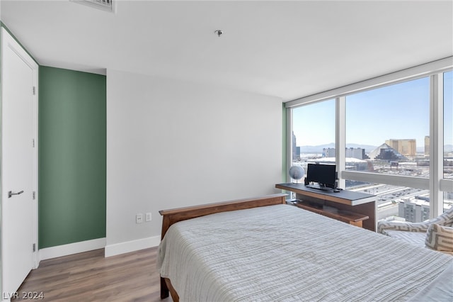 bedroom featuring multiple windows and hardwood / wood-style floors