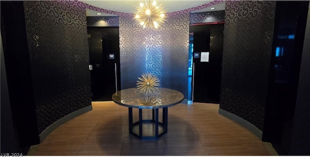 hall featuring tile floors and a chandelier