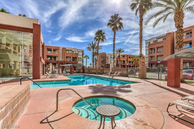 view of swimming pool featuring a community hot tub and a patio