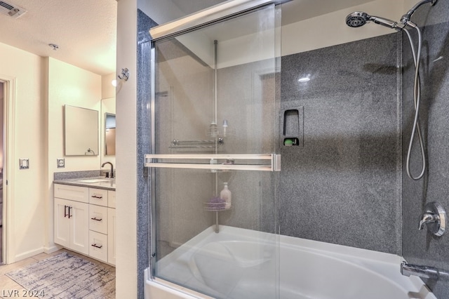 bathroom with tile flooring, combined bath / shower with glass door, and vanity