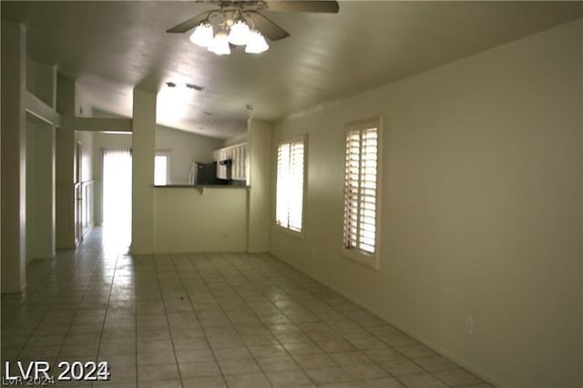 tiled spare room featuring ceiling fan and vaulted ceiling