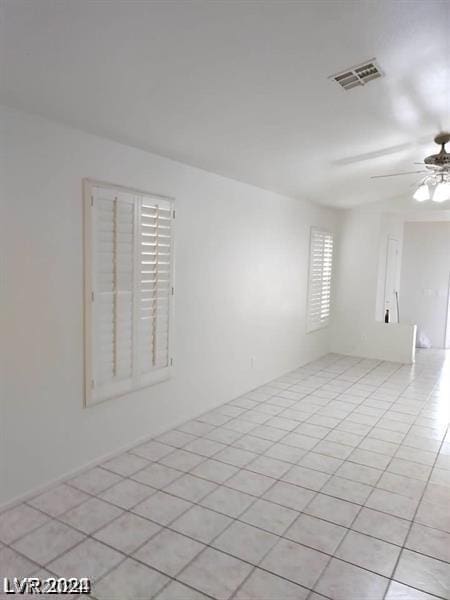 tiled empty room featuring ceiling fan