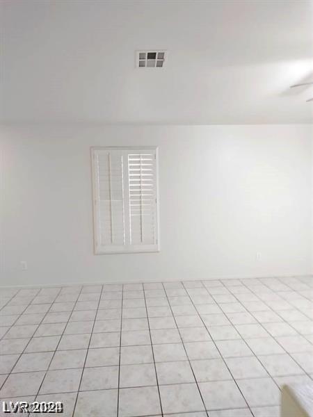 empty room featuring ceiling fan and light tile patterned flooring