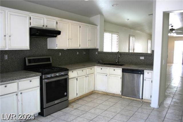 kitchen featuring backsplash, white cabinets, sink, light tile patterned floors, and stainless steel appliances