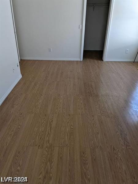 unfurnished bedroom with dark hardwood / wood-style floors and a closet