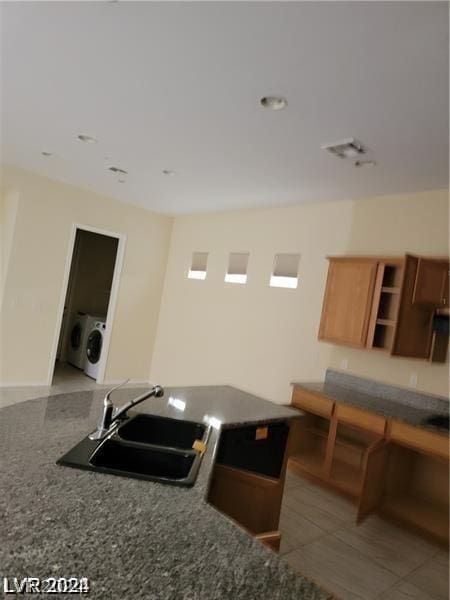 kitchen with tile patterned flooring, washer / dryer, and sink