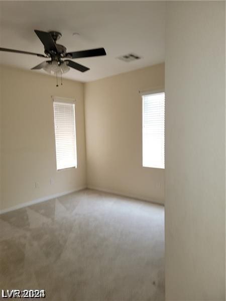 carpeted spare room featuring ceiling fan