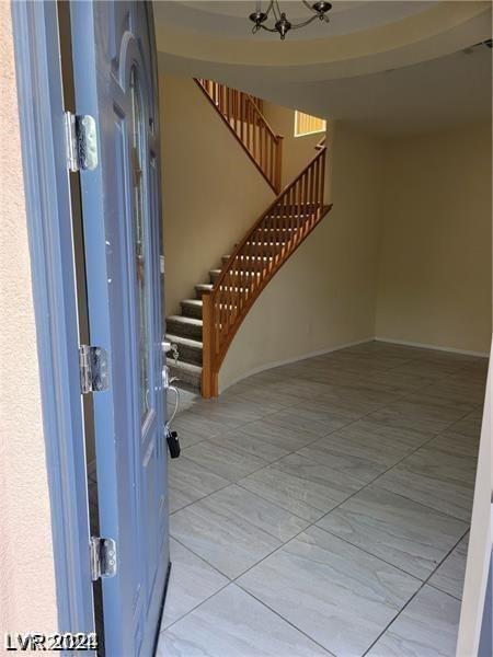 entrance foyer featuring a chandelier and light tile floors