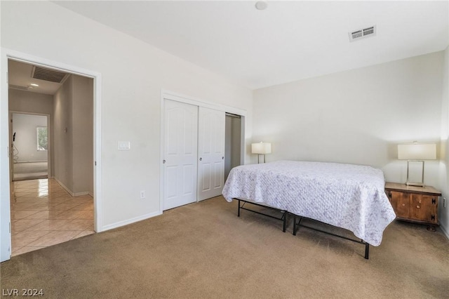 bedroom with a closet and light carpet