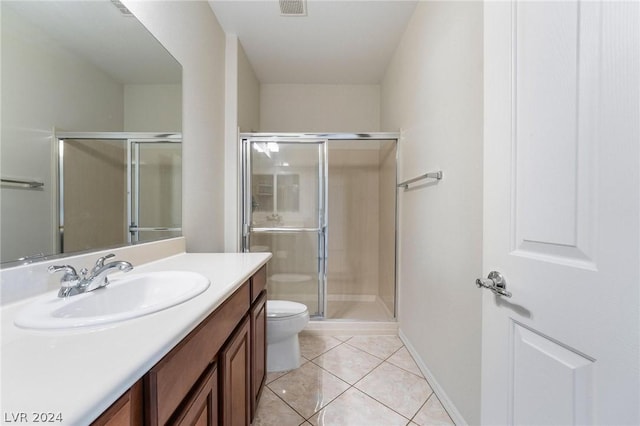 bathroom with vanity, a shower with door, tile patterned floors, and toilet