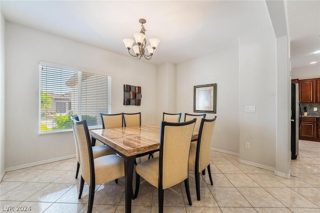 tiled dining room with a notable chandelier