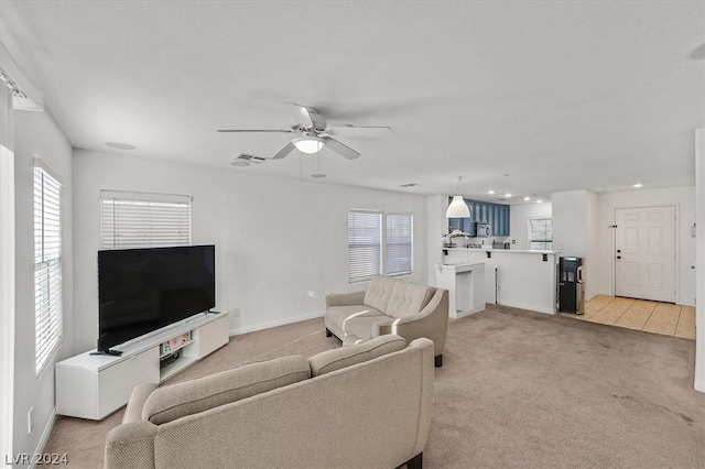 carpeted living room featuring ceiling fan