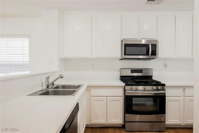 1161 Gecko Rd, Henderson, NV 89002 - kitchen with stainless steel appliances, a sink, white cabinets, and light countertops