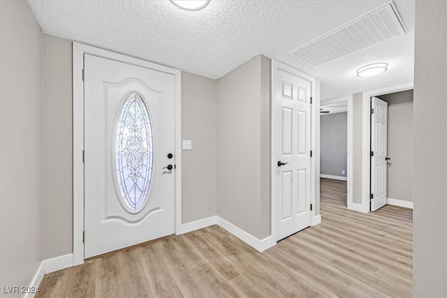 entrance foyer featuring light hardwood / wood-style flooring and a textured ceiling