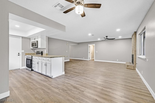 kitchen featuring light stone counters, light hardwood / wood-style flooring, white cabinets, and stainless steel appliances