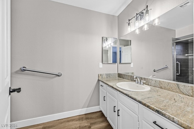 bathroom with hardwood / wood-style flooring, vanity, and an enclosed shower