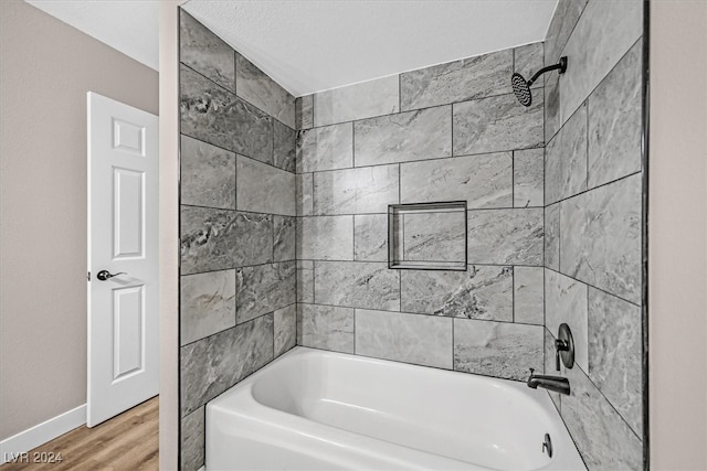 bathroom featuring hardwood / wood-style flooring and tiled shower / bath