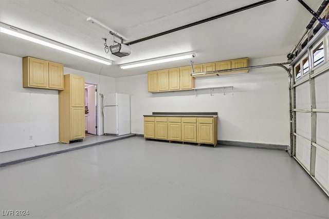 garage with white fridge and a garage door opener