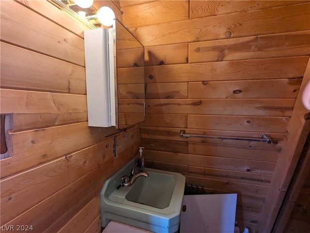 bathroom with wood walls and sink