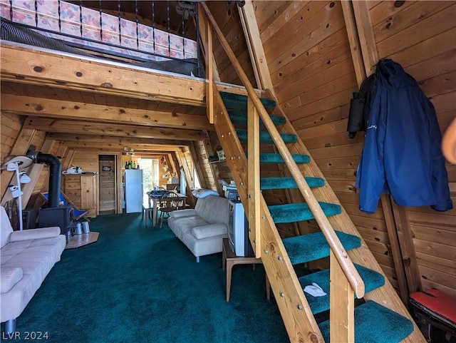 carpeted bedroom featuring beam ceiling and wood walls