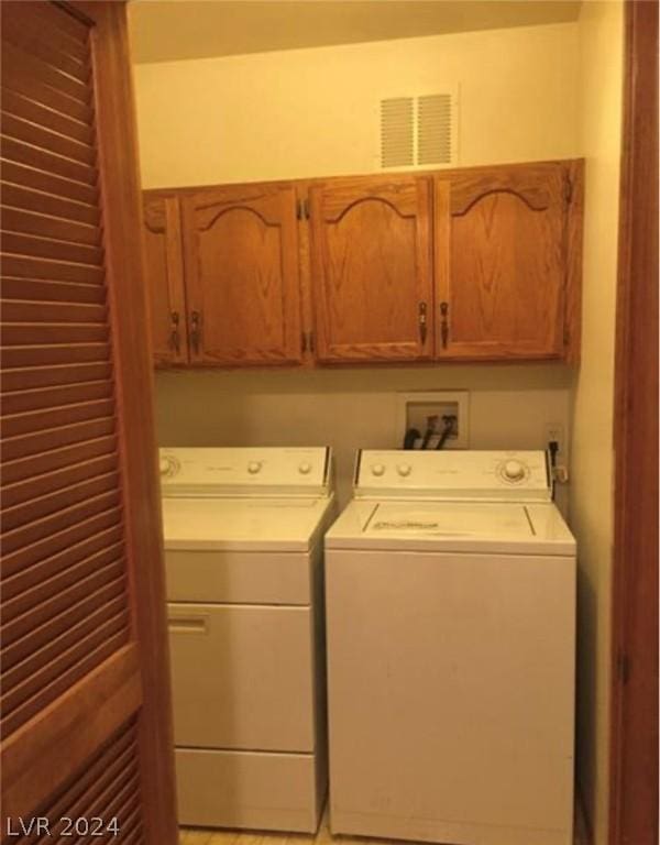 laundry room featuring washing machine and dryer and cabinets