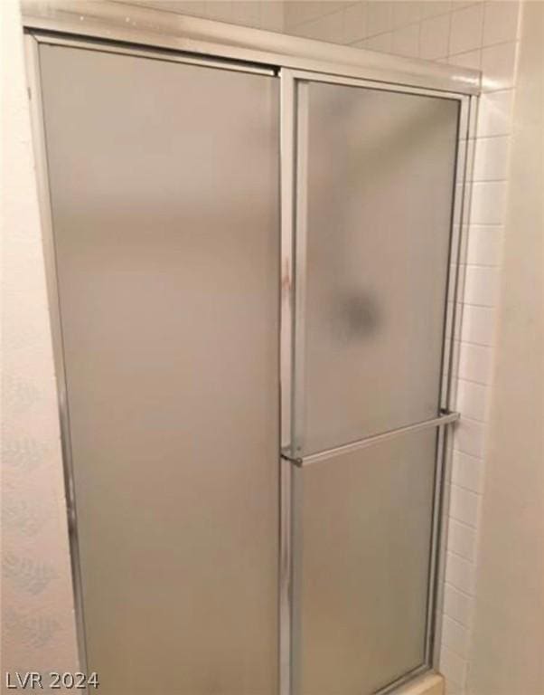 bathroom featuring a shower with door