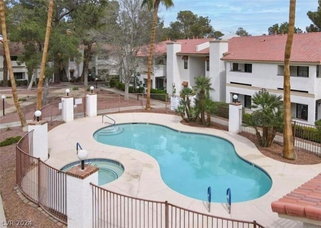 view of pool with a patio area and a hot tub