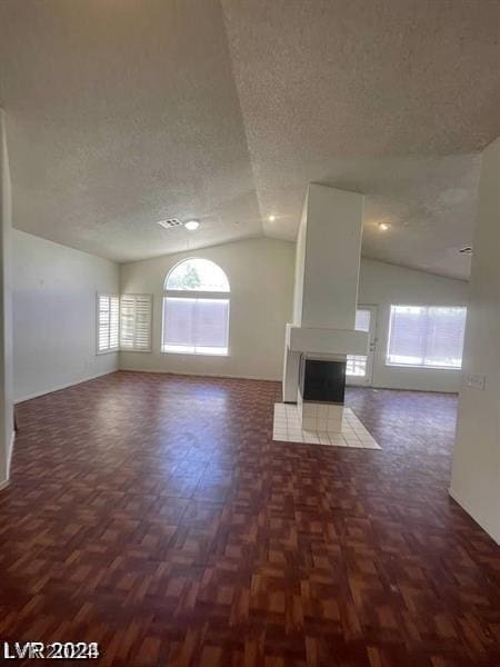 unfurnished living room featuring a multi sided fireplace, lofted ceiling, a textured ceiling, and dark parquet flooring