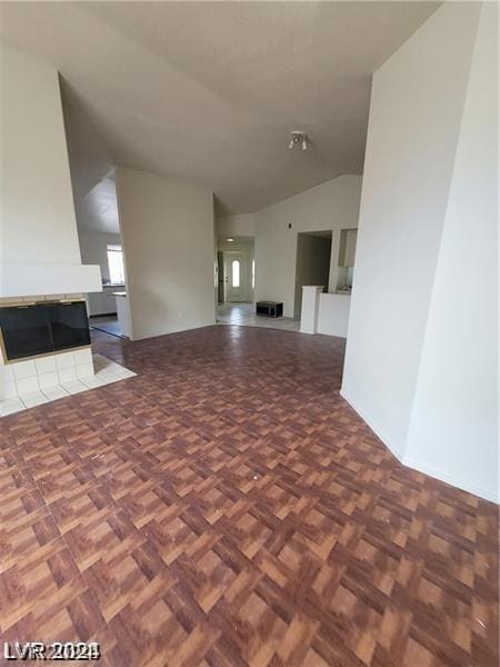 interior space with a multi sided fireplace, parquet floors, and lofted ceiling