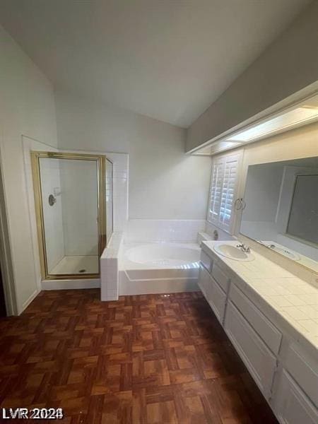 bathroom with separate shower and tub, vanity, vaulted ceiling, and parquet flooring