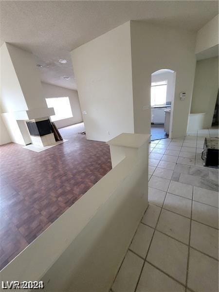 corridor featuring light tile patterned floors and vaulted ceiling