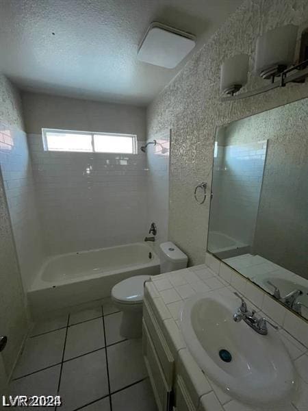 full bathroom with vanity, tile patterned floors, tiled shower / bath combo, toilet, and a textured ceiling