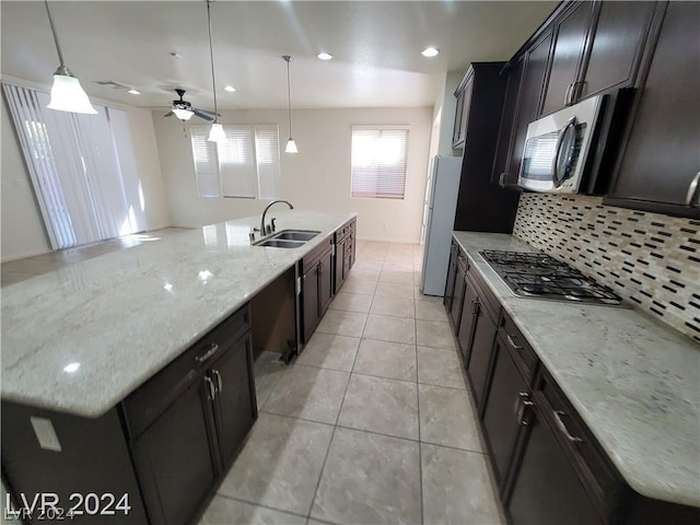 kitchen featuring pendant lighting, a center island with sink, sink, and appliances with stainless steel finishes